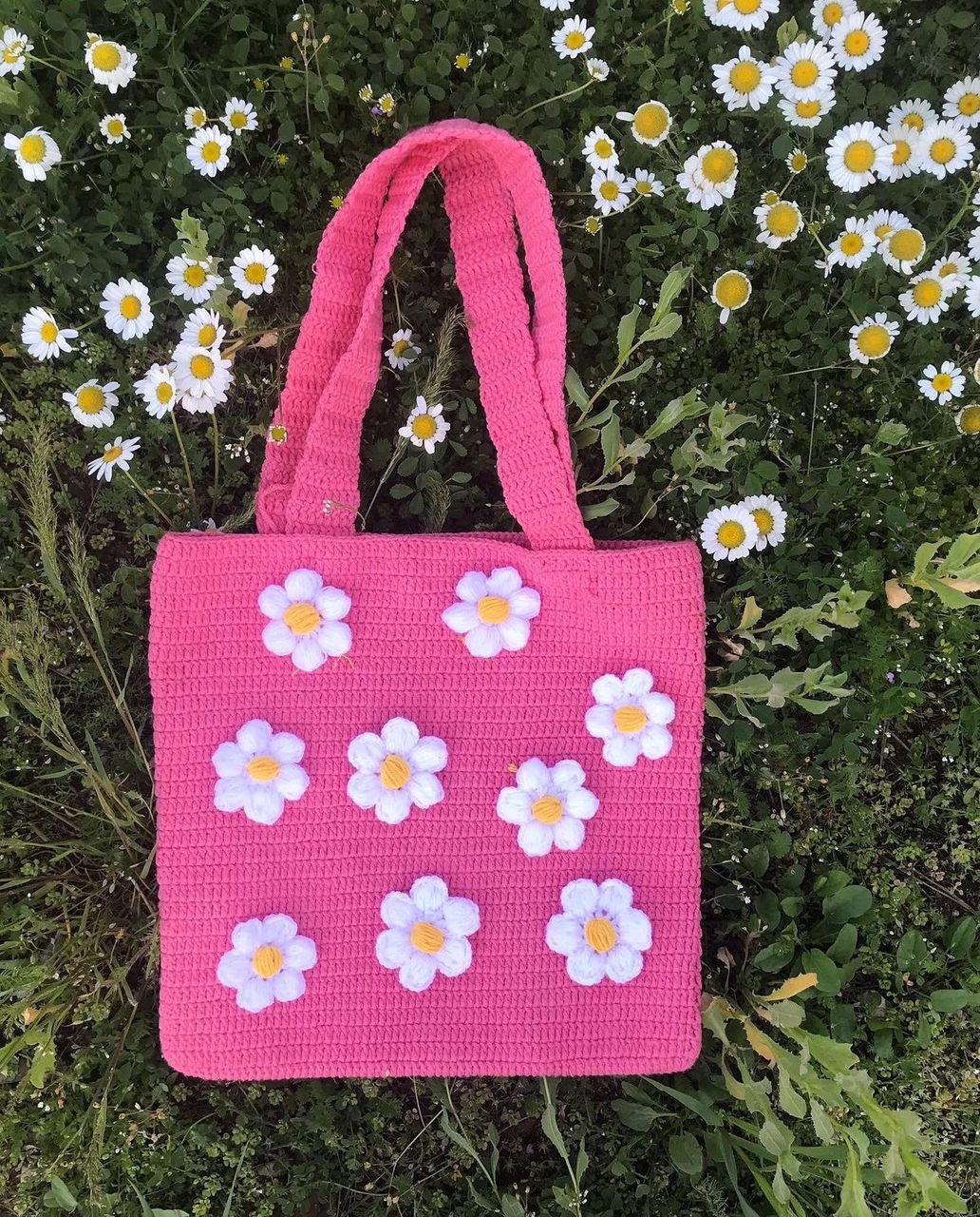 Hot pink crochet tote bag with white daisy appliqués